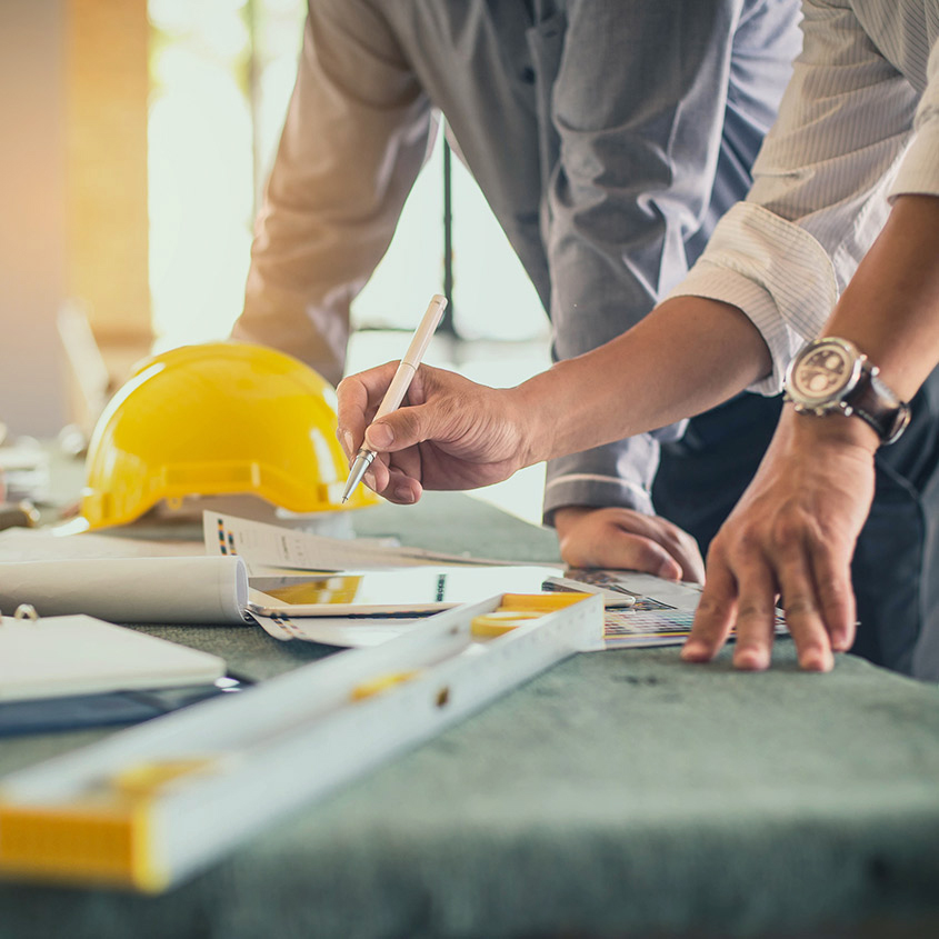 Business owner and financial advisor going over construction plans
